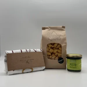 Set mit Weihnachtstuch, Spiralnudeln und Wildkräuterpesto auf weißem Hintergrund.